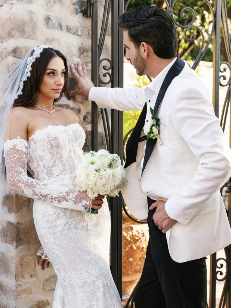 Intimate editorial couple portrait showcasing a strapless lace mermaid gown and cathedral mantilla veil during golden wedding coverage hours.
