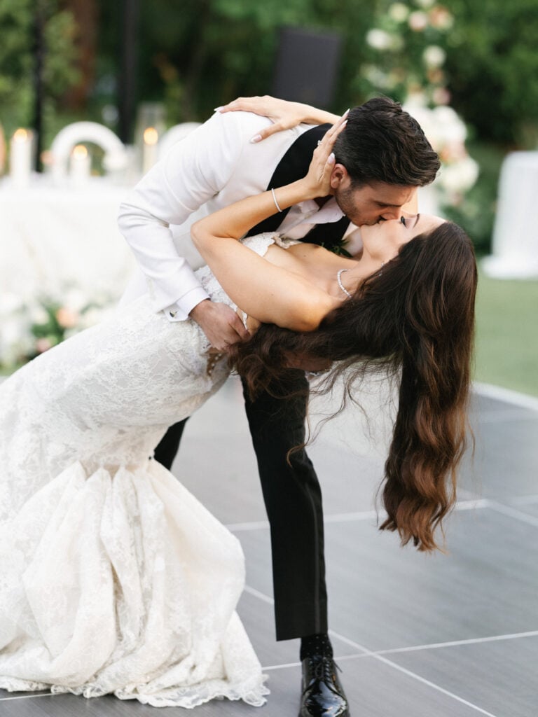 High-fashion wedding reception dip kiss on a custom monogrammed dance floor.