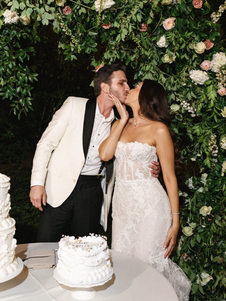 Romantic cake cutting kiss during late wedding coverage hours at an elegant Hummingbird Nest Ranch reception.