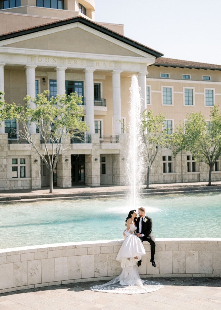 Editorial couple portrait by the grand fountain at Founders Hall, showcasing bright architectural backdrops perfect for timeless wedding venue photography.