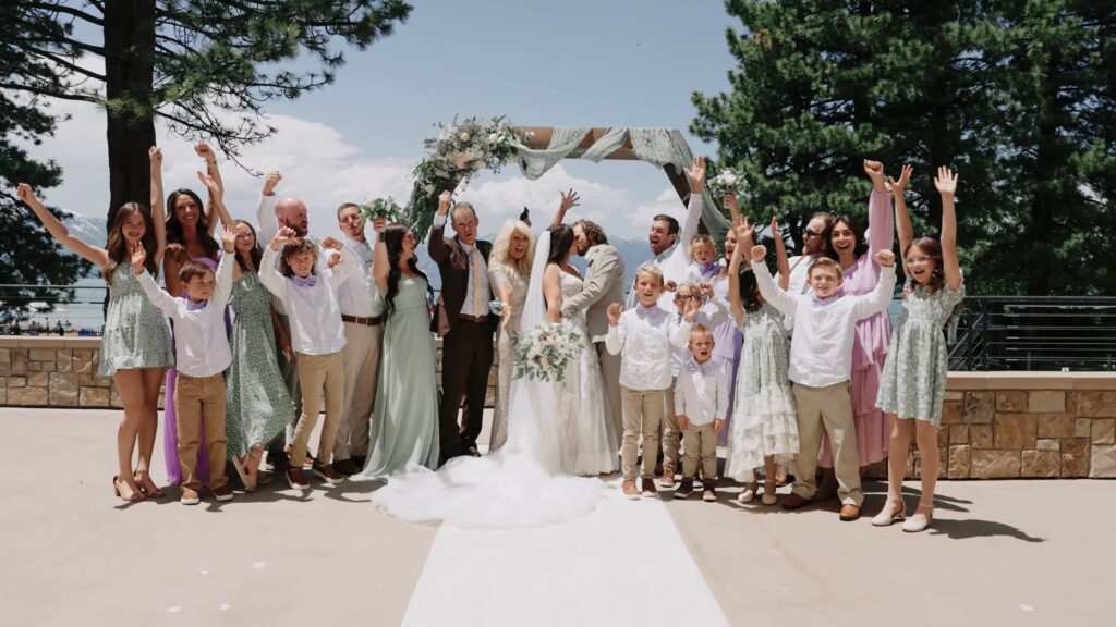 Wedding party and guests cheering around newlyweds at a mountain terrace ceremony, shot by a Lake Tahoe wedding photographer.