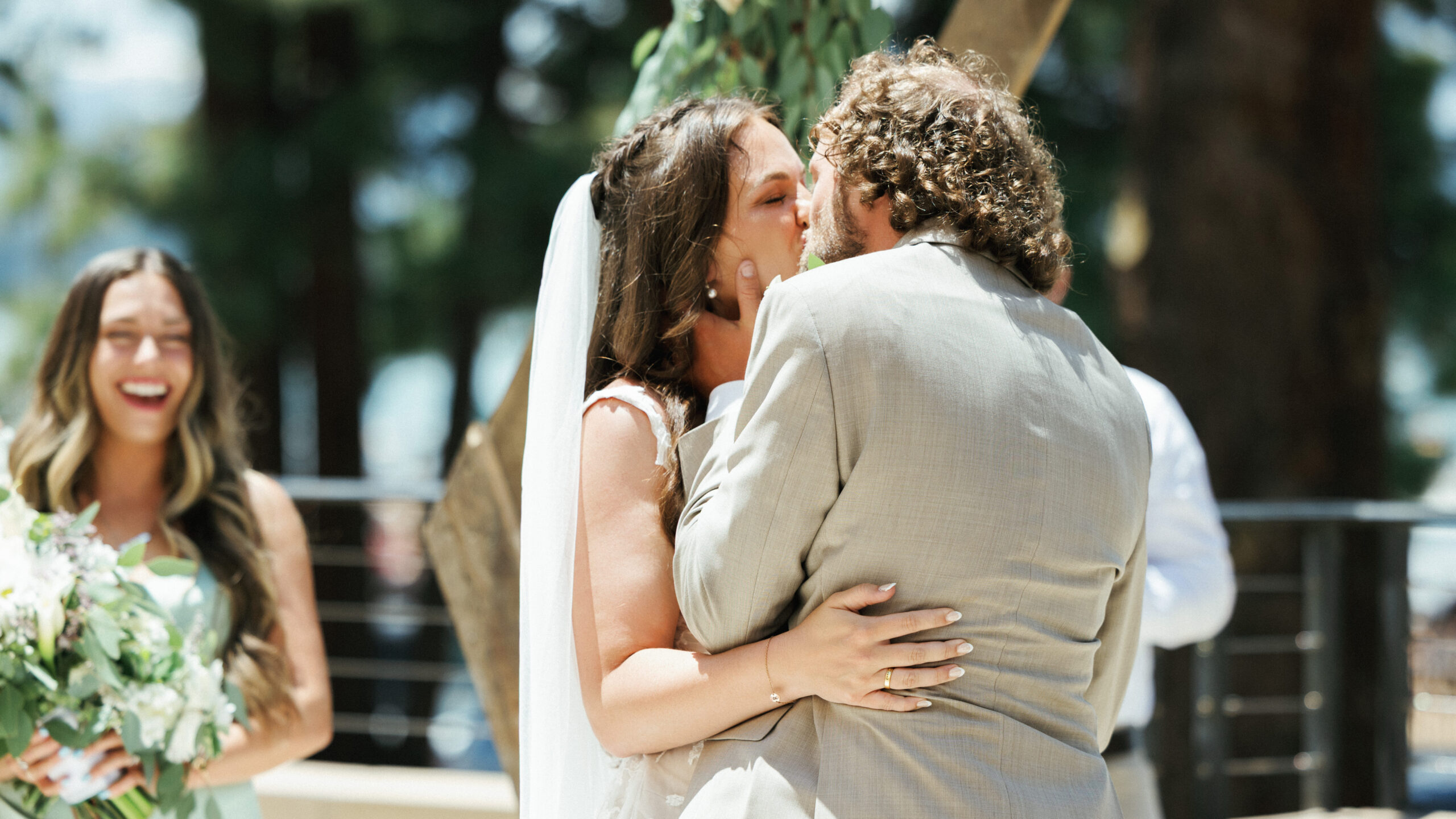 Bride and groom sharing their first kiss during a sunny outdoor ceremony captured by a Lake Tahoe wedding photographer