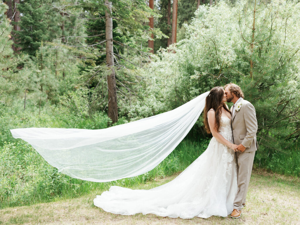 Lake tahoe forest wedding photography featuring a bride in a lace gown and a groom in a tan suit