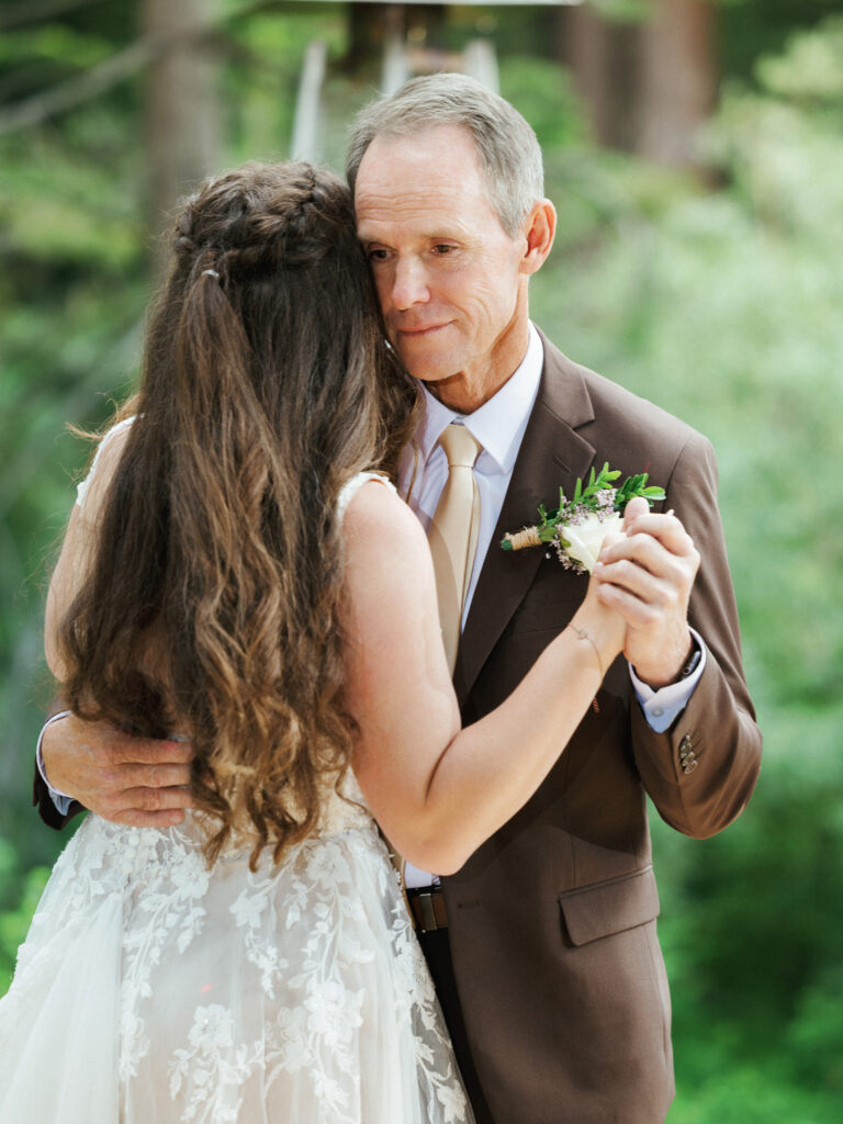 Bride in a lace gown dancing with her father in a brown suit fine art Lake Tahoe wedding photography