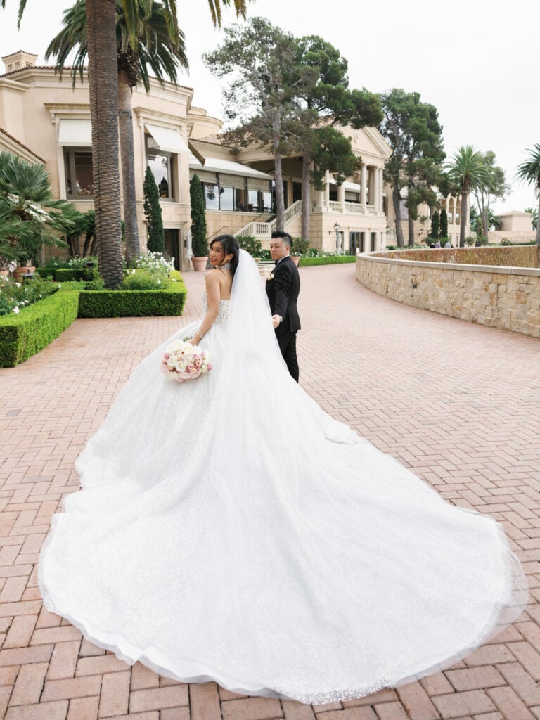 Dramatic royal wedding train inspiration at The Resort at Pelican Hill, showcasing luxury bridal look aesthetics in soft overcast light.