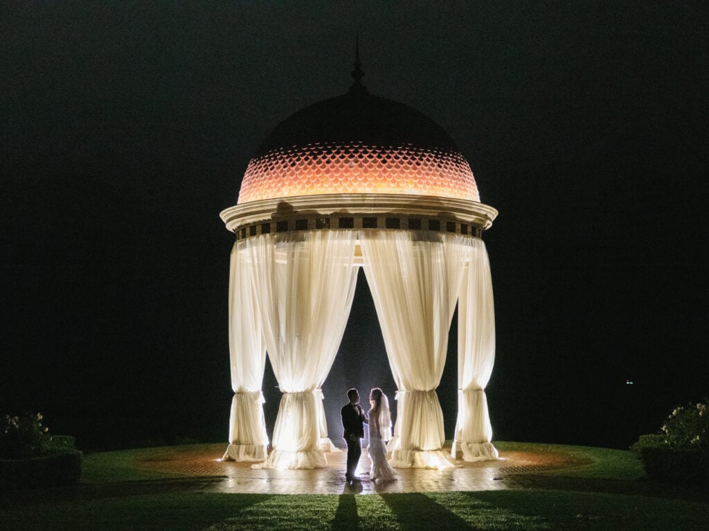 Magical evening wedding portrait in the rain at The Resort at Pelican Hill, proving that a rainy day enhances high-end storytelling.