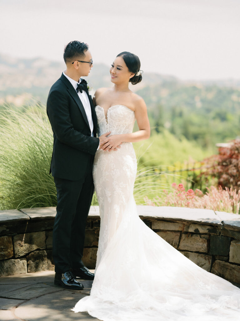 Elegant couple looking at each other on a scenic outdoor terrace, shot on film by a professional Napa Valley wedding photographer.