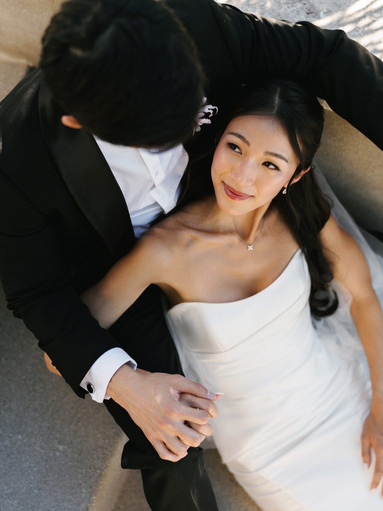 Intimate close-up wedding photo ideas capturing a tender glance between a luxury bride and groom holding hands.