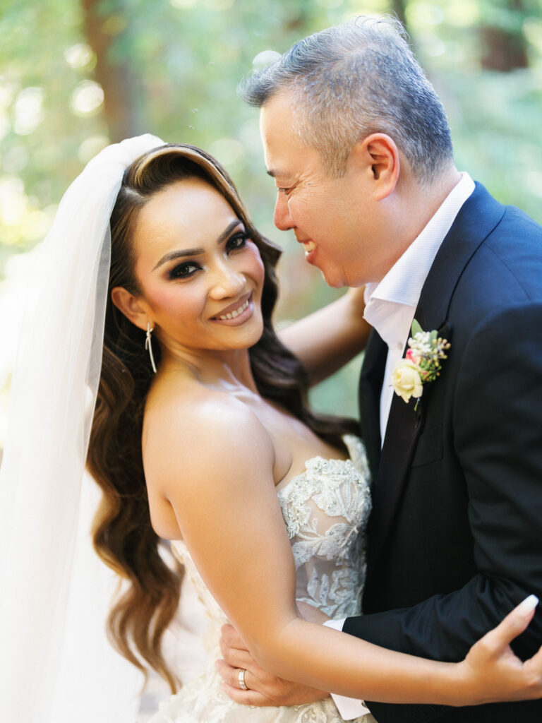 Smiling bride hugging her groom during a close up outdoor portrait session captured by a Big Sur wedding photographer