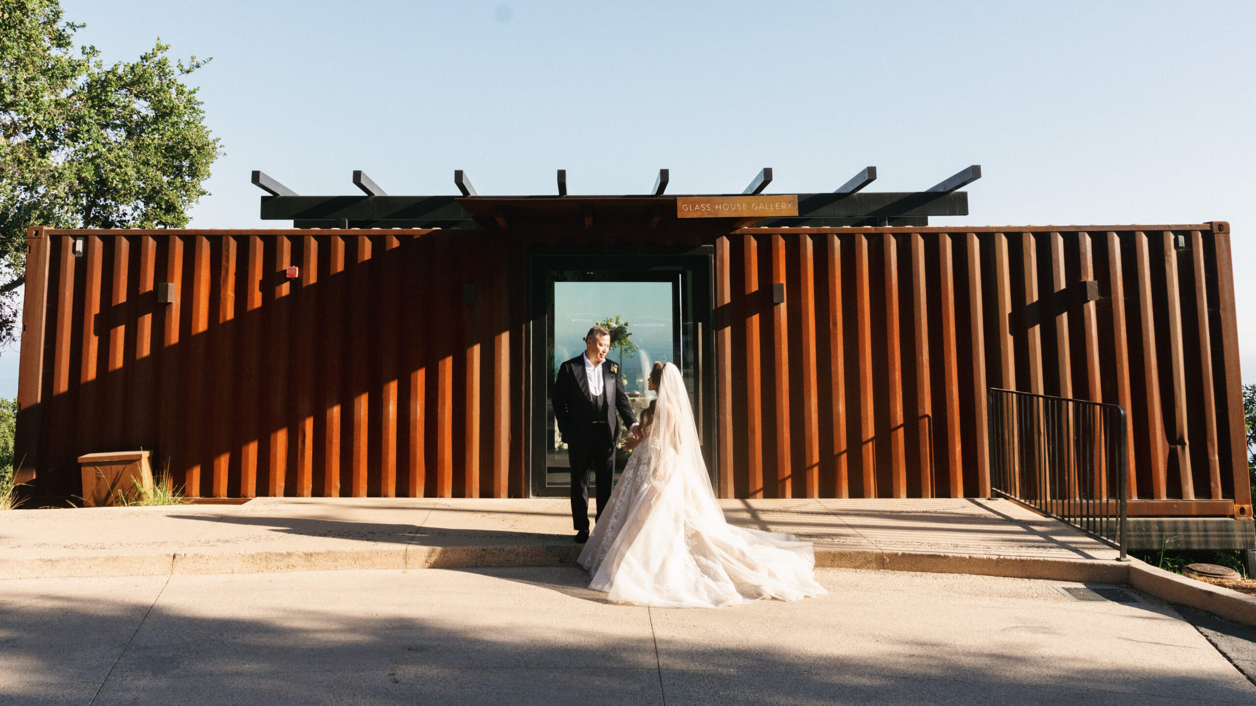 Bride and groom posing by a modern corten steel venue for a Big Sur wedding photographer timeline planning guide