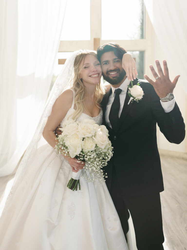 Newlywed couple posing for a bright indoor portrait during a celebration planned using expert texas summer wedding tips