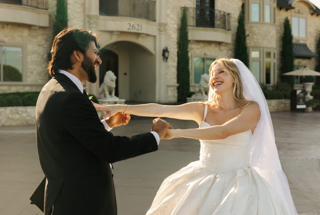 Candid wedding portrait capturing a happy couple dancing together under warm evening sunset light