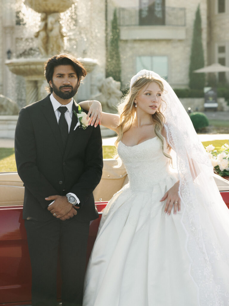 Bride and groom standing next to a classic getaway car following helpful texas summer wedding tips for outdoor portraits