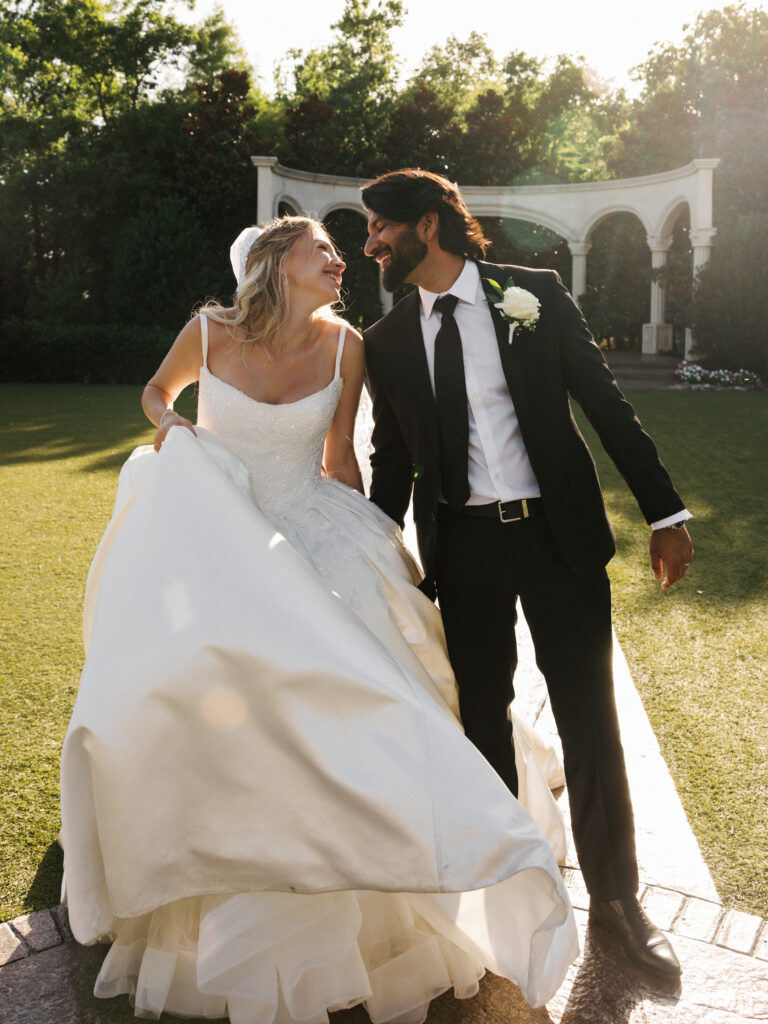 Sunset lighting illuminating a bride and groom on a lawn during a celebration planned with top texas summer wedding tips