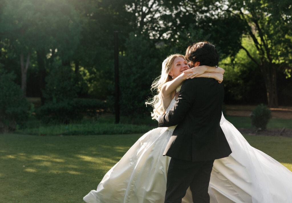 Candid wedding photography capturing a joyful moment of a newlyweds embrace under soft evening sunlight