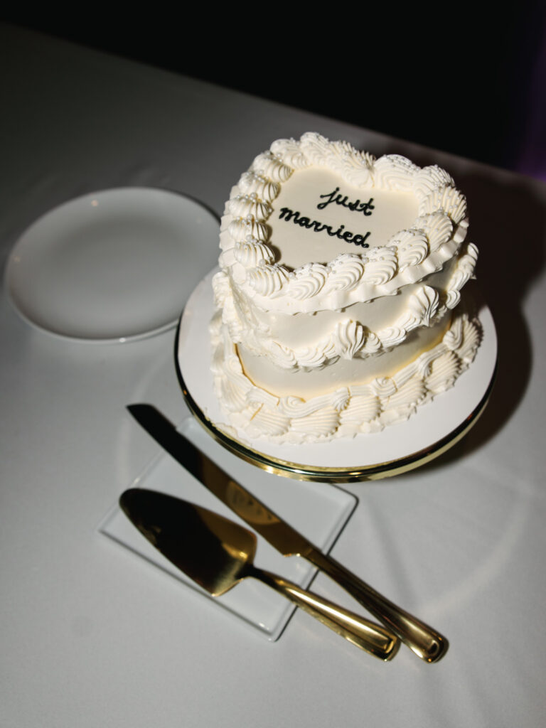 Vintage heart wedding cake with white piping details and gold serving utensils